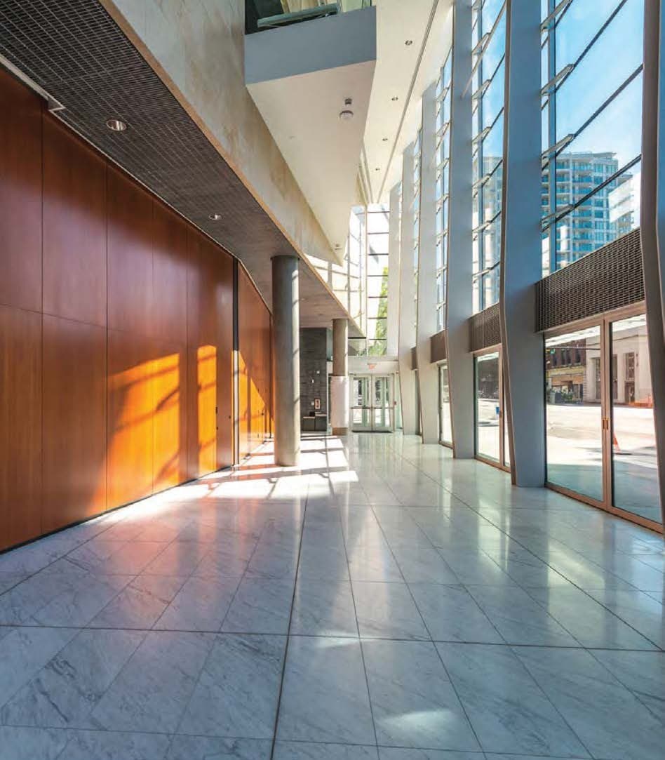Sunlit commercial lobby with marble floor and timber panelling